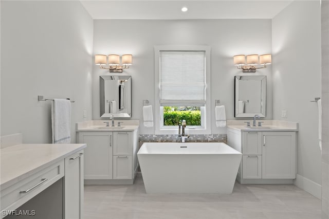 full bathroom featuring a soaking tub, two vanities, and recessed lighting