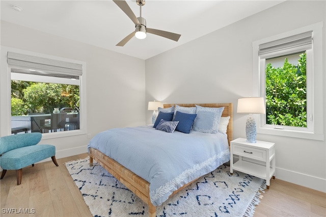 bedroom featuring baseboards, wood finished floors, and a ceiling fan