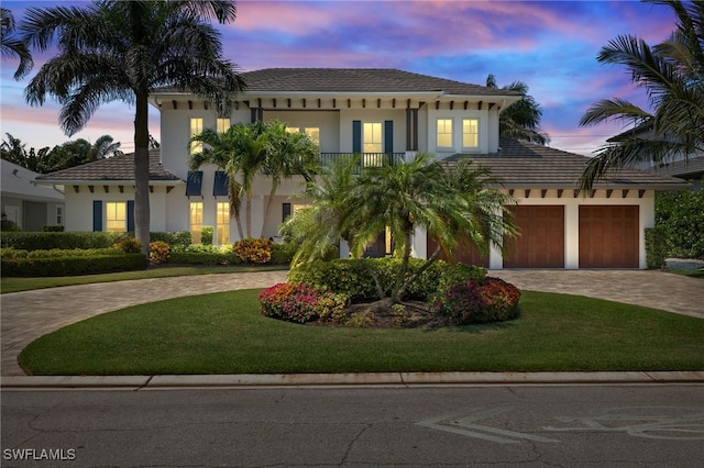mediterranean / spanish house with curved driveway, stucco siding, and a front yard