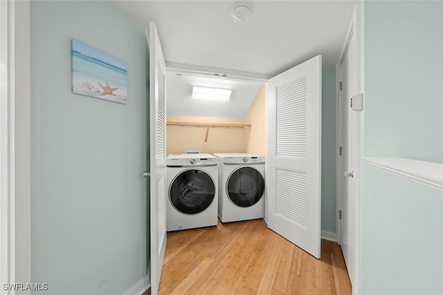 laundry room with separate washer and dryer, light wood finished floors, and baseboards