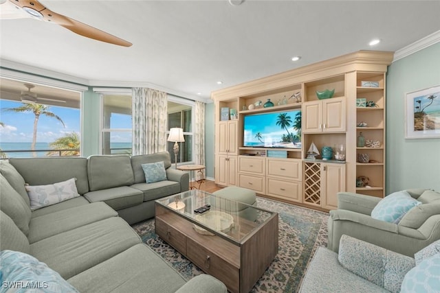 living area with crown molding, recessed lighting, a ceiling fan, and a water view
