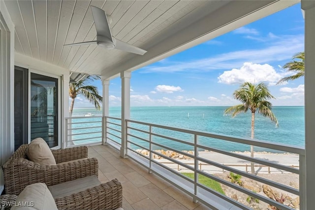 balcony featuring a water view and a ceiling fan