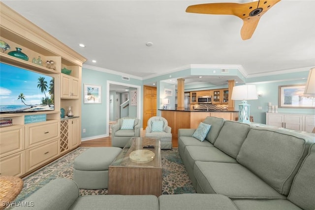 living area featuring crown molding, ceiling fan, recessed lighting, baseboards, and wood finished floors