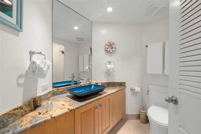 bathroom with toilet, recessed lighting, vanity, tile patterned floors, and baseboards