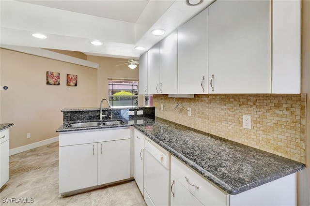 kitchen with dishwasher, a sink, a peninsula, a ceiling fan, and backsplash