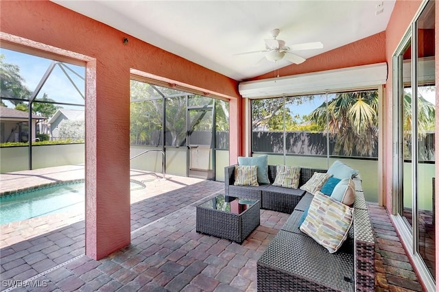 sunroom / solarium with lofted ceiling, ceiling fan, and an outdoor living space