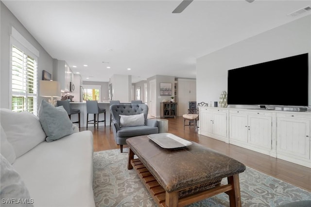 living room with light wood-style floors, ceiling fan, and recessed lighting
