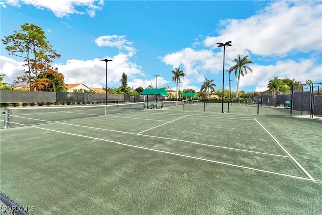 view of tennis court featuring fence