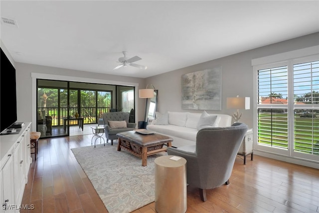 living room featuring a ceiling fan and light wood-style floors