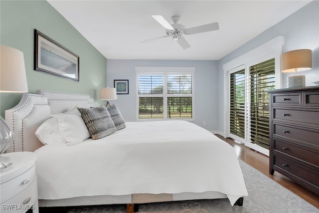 bedroom featuring dark wood-style flooring, ceiling fan, baseboards, and access to outside
