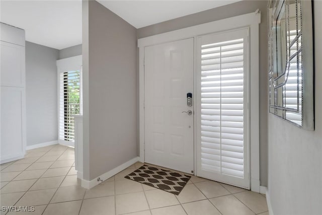 entryway featuring baseboards and light tile patterned floors
