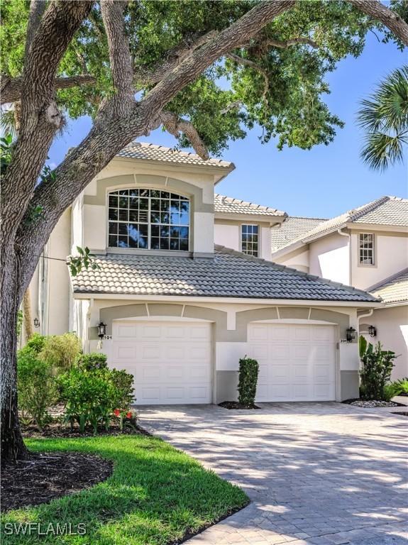 view of front of property featuring stucco siding, driveway, and a tile roof