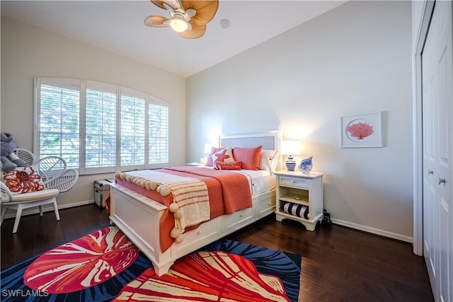 bedroom featuring dark wood-style floors, vaulted ceiling, baseboards, and ceiling fan