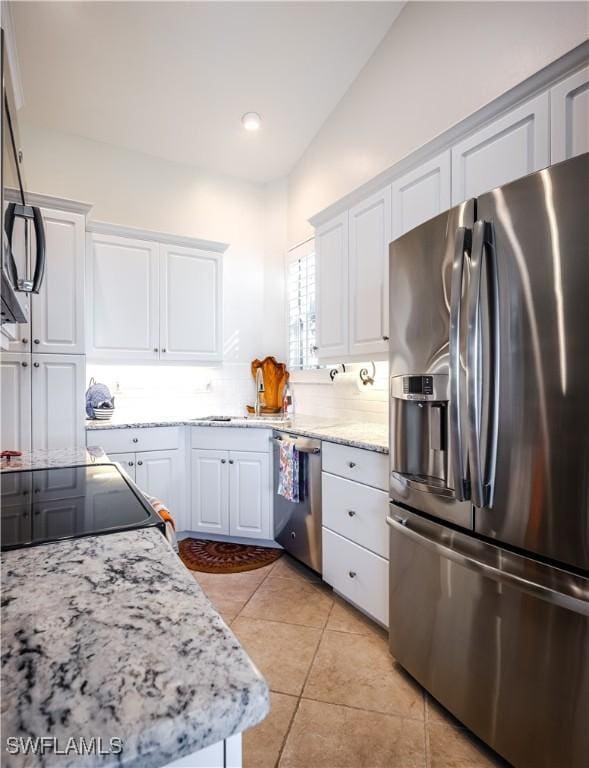 kitchen with appliances with stainless steel finishes, white cabinets, light tile patterned floors, and recessed lighting