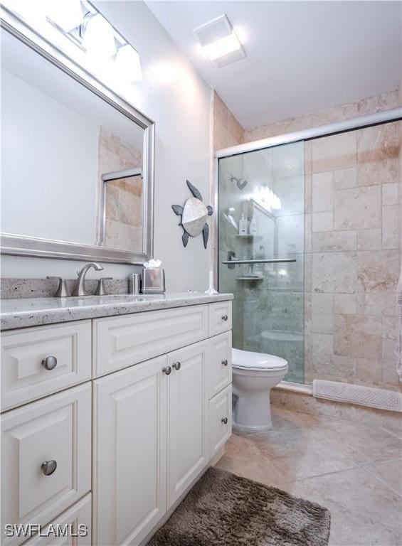 bathroom featuring a stall shower, toilet, and vanity