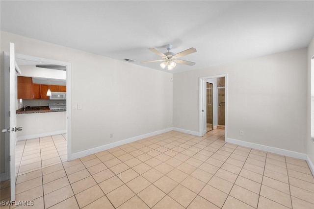 empty room with light tile patterned floors, visible vents, baseboards, and ceiling fan