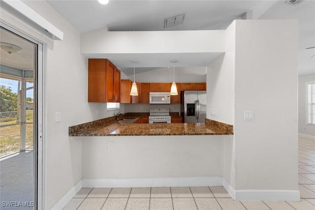 kitchen featuring light tile patterned floors, plenty of natural light, visible vents, white appliances, and vaulted ceiling