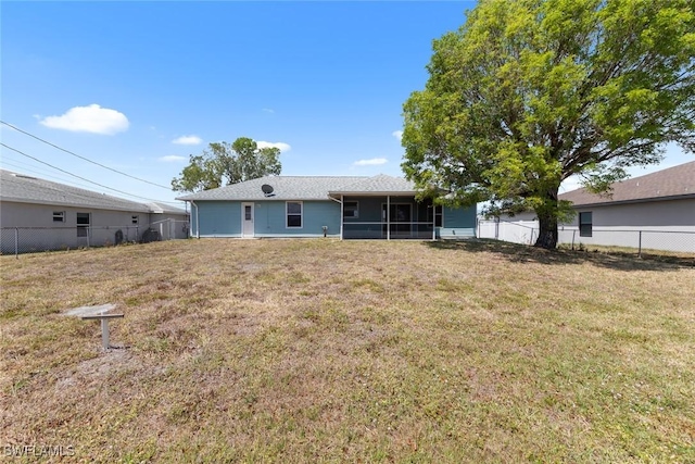 back of property featuring a yard, a sunroom, and fence
