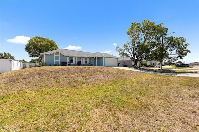 ranch-style house featuring concrete driveway, a front lawn, a garage, and fence