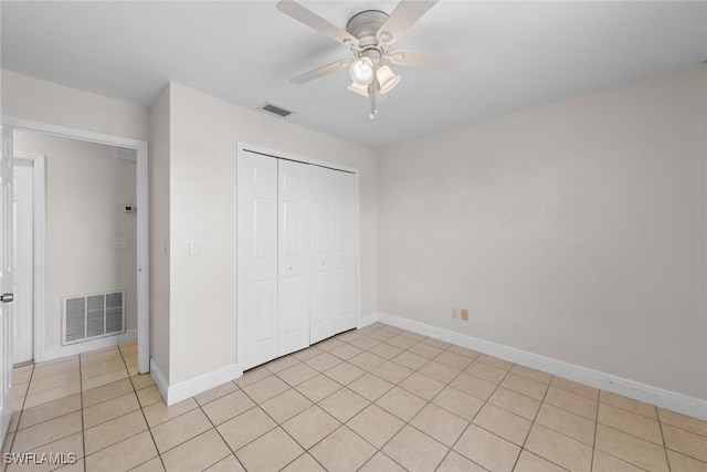 unfurnished bedroom with baseboards, a closet, light tile patterned floors, and visible vents