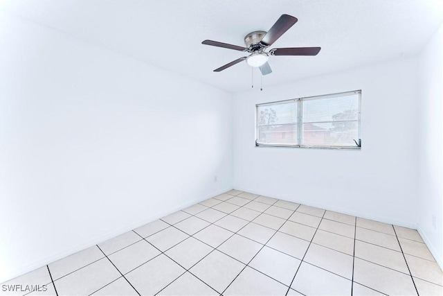 unfurnished room featuring ceiling fan, light tile patterned flooring, and baseboards