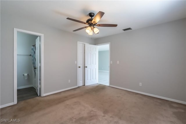 5295 17th Ave SW, Naples, FL 34116 - unfurnished bedroom featuring baseboards, connected bathroom, a ceiling fan, and carpet floors