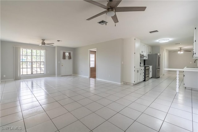 5295 17th Ave SW, Naples, FL 34116 - unfurnished living room with a wealth of natural light, baseboards, a ceiling fan, and visible vents
