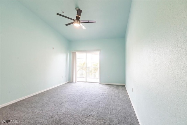 carpeted spare room featuring baseboards, lofted ceiling, and a ceiling fan