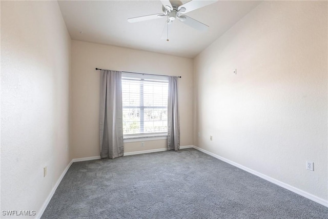 carpeted empty room featuring a ceiling fan and baseboards