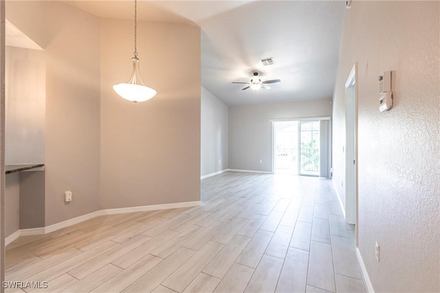 empty room featuring light wood finished floors, visible vents, baseboards, and a ceiling fan