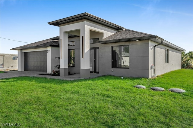 prairie-style house with a shingled roof, stucco siding, an attached garage, and a front yard
