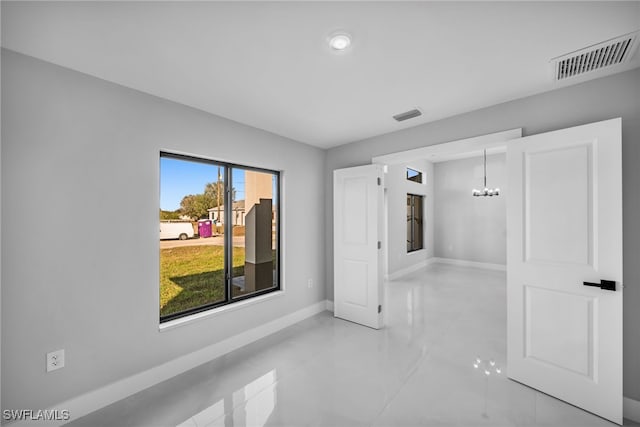 interior space featuring baseboards, a notable chandelier, tile patterned floors, and visible vents