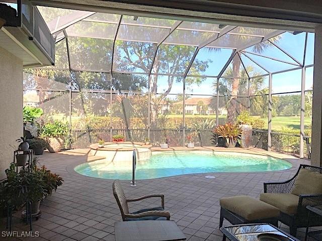 view of swimming pool with a lanai, a patio, and a pool with connected hot tub