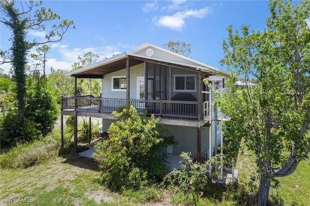8625 Redwood Dr, Saint James City, FL 33956 - rear view of property featuring a sunroom and a wooden deck