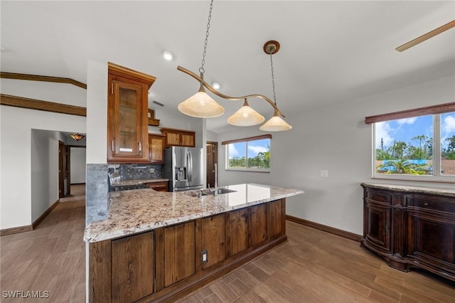 8625 Redwood Dr, Saint James City, FL 33956 - kitchen featuring stainless steel fridge, a sink, baseboards, light stone counters, and vaulted ceiling