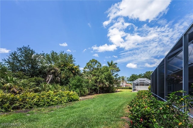 view of green lawn with glass enclosure