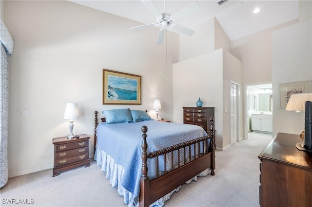 bedroom with high vaulted ceiling, light colored carpet, baseboards, ensuite bathroom, and ceiling fan