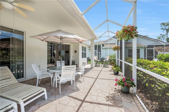 sunroom / solarium featuring outdoor dining area, a ceiling fan, and lofted ceiling