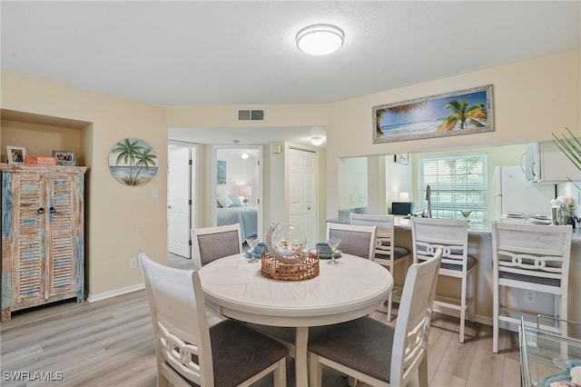 dining room with light wood-style flooring and baseboards