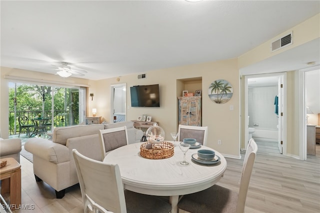 dining room with light wood-style flooring, a ceiling fan, and baseboards