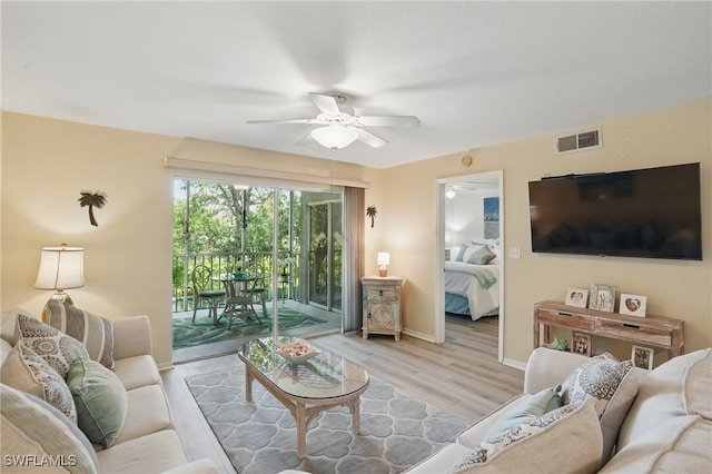 living area featuring ceiling fan, wood finished floors, and baseboards