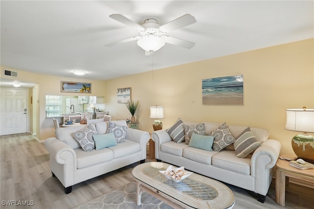 living area featuring light wood finished floors and ceiling fan