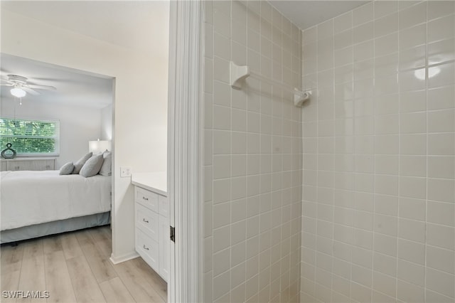 full bath with ensuite bath, a ceiling fan, and wood finished floors