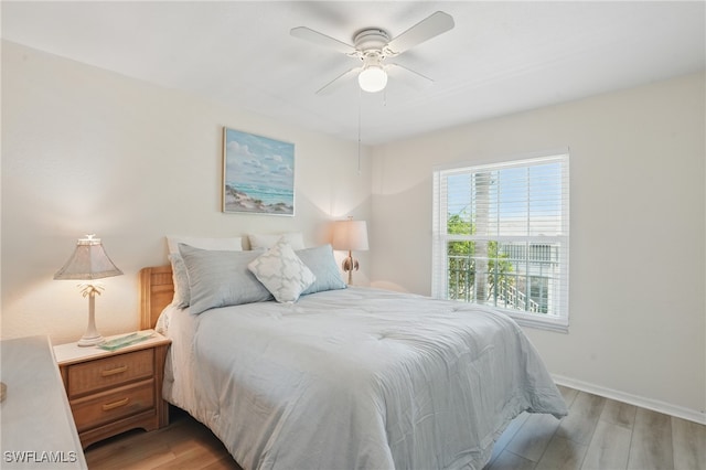 bedroom with light wood-type flooring, baseboards, and a ceiling fan