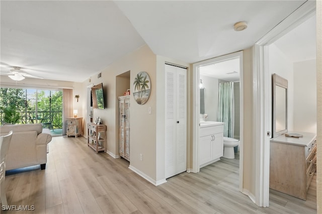 hall featuring light wood finished floors and baseboards