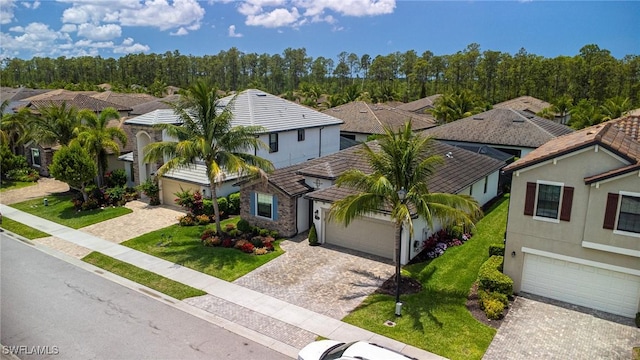 9231 Shadow Oak Ln, Naples, FL 34120 - mediterranean / spanish house featuring a front lawn, decorative driveway, stucco siding, and a residential view