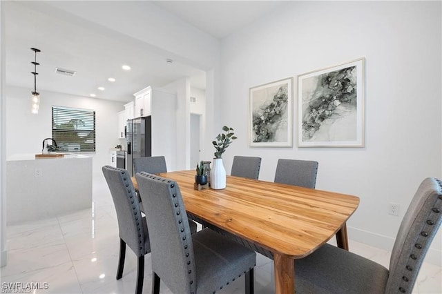 dining room with light marble finish floors, recessed lighting, and baseboards