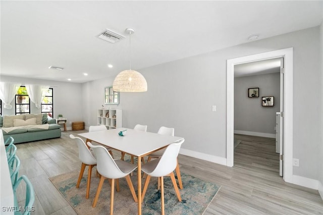 dining room with baseboards, light wood-style floors, and recessed lighting