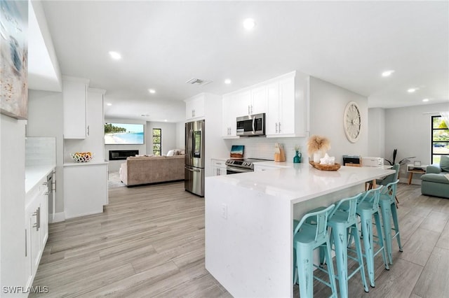 kitchen with stainless steel appliances, open floor plan, recessed lighting, and plenty of natural light