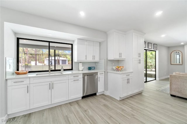 kitchen featuring stainless steel dishwasher, recessed lighting, light countertops, light wood-style flooring, and white cabinets